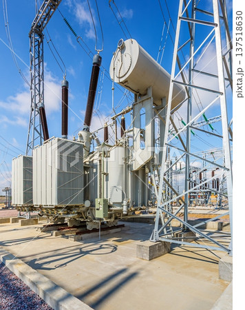 Vertical view of an outdoor electrical distribution substation, without people, at daytime on a background of a clear blue sky Vertical view of an outdoor electrical distribution substation, without people, at daytime on a background of a clear blue sky 137518630