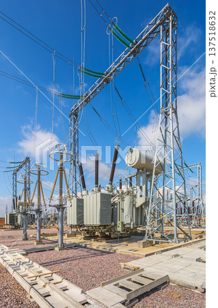 Vertical view of an outdoor electrical distribution substation, without people, at daytime on a background of a clear blue sky 137518632