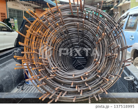 A roll of industrial steel reinforcement wire mesh loaded on the bed of a pickup truck for transport to a construction site. Close up view of the circular metal patterns and rusty texture. A roll of industrial steel reinforcement wire mesh loaded on the bed of a pickup truck for transport to a construction site. Close up view of the circular metal patterns and rusty texture. 137518995