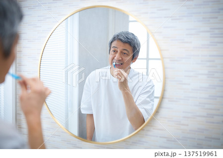鏡を見ながら歯磨きをする60代男性 鏡を見ながら歯磨きをする60代男性 137519961