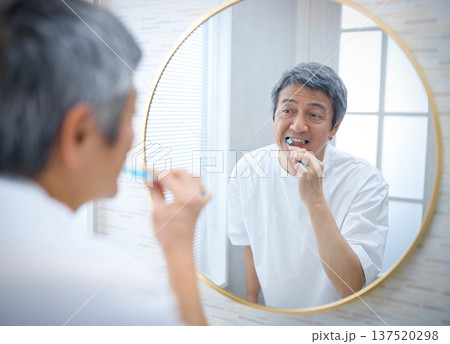 鏡を見ながら歯磨きをする60代の男性 137520298