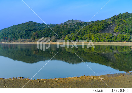 青空の下、雨不足で干上がった湖底と静かな湖面の風景 青空の下、雨不足で干上がった湖底と静かな湖面の風景 137520300