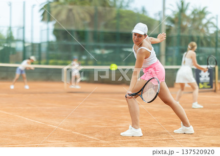 Woman playing tennis against female opponent on tennis court Woman playing tennis against female opponent on tennis court 137520920