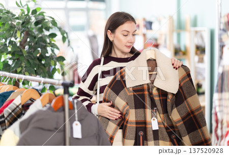 Young woman chooses jacket in clothing store 137520928