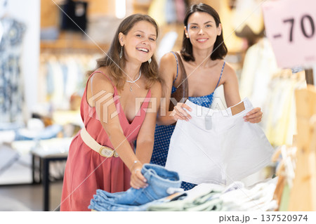 Two girls customer chooses shorts in store 137520974