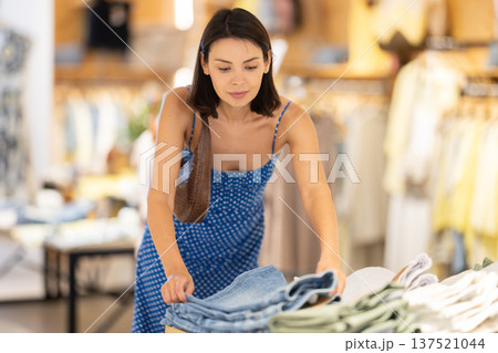 Girl customer chooses shorts in store 137521044