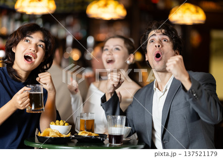group of people in a sports bar rejoicing at the teams win 137521179