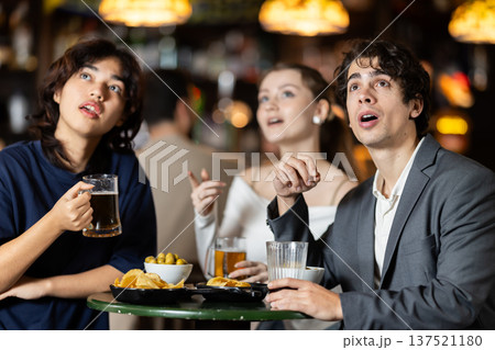 Group of friends watching sports match at bar 137521180
