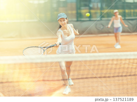 Female athlete plays tennis on open court 137521189