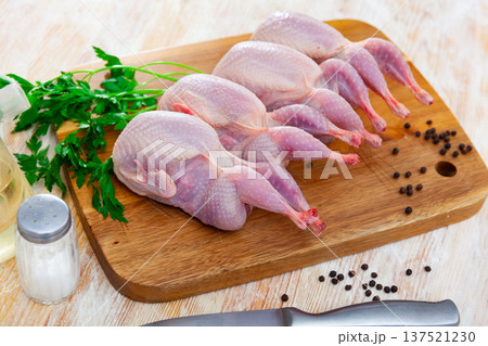 Raw gutted quails and condiments prepared for cooking on wooden table Raw gutted quails and condiments prepared for cooking on wooden table 137521230