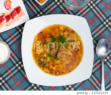 Shchi, cabbage soup cooked on mushroom broth with pork and sour cream Shchi, cabbage soup cooked on mushroom broth with pork and sour cream 137521235