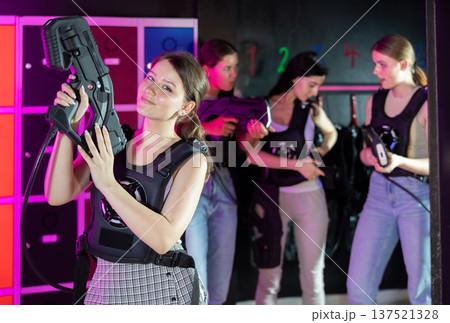 Cheerful and happy girl pose in locker room before laser tag match. 137521328