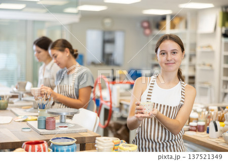 Teenage girl with handmade ceramic cup in workshop Teenage girl with handmade ceramic cup in workshop 137521349