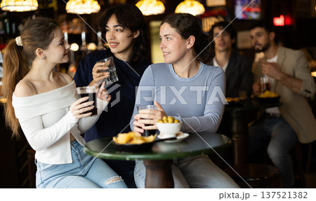 Happy women friends have fun and drinking beer on party in bar 137521382