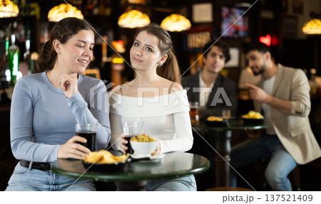 Two young women chatting and drinking beer at bar Two young women chatting and drinking beer at bar 137521409