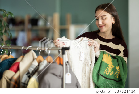 Young woman choosing sweater in clothing store Young woman choosing sweater in clothing store 137521414
