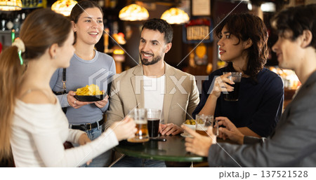 Group of friends at bar talking and drinking beer Group of friends at bar talking and drinking beer 137521528