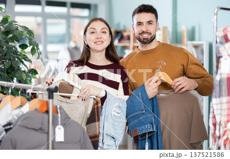 Couple with lot of clothes goods in hands. 137521586