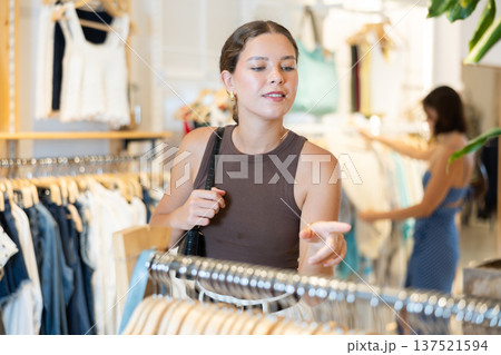 Young woman choosing clothes in a store in summer Young woman choosing clothes in a store in summer 137521594