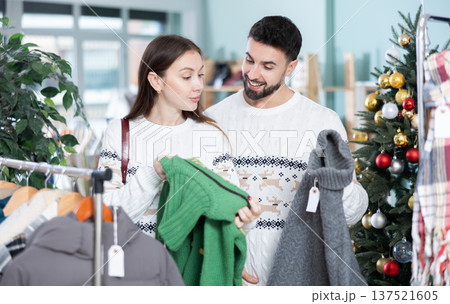 Couple at trading floor pick out and buying sweater, X mas shopping Couple at trading floor pick out and buying sweater, X mas shopping 137521605