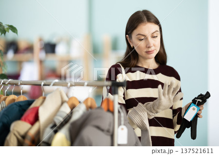 Young woman choosing gloves in clothing store 137521611