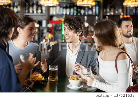Group of friends at bar talking and drinking beer 137521635