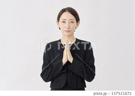 喪服を着た女性　合掌　白背景　カメラ目線 137521872