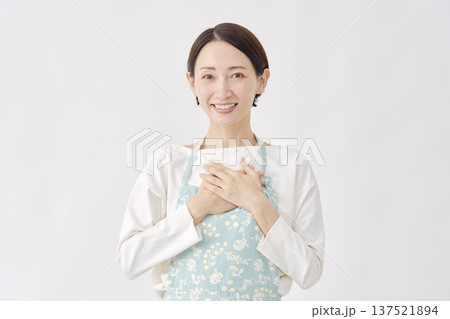 ほっとするエプロンを着た女性 白背景 ほっとするエプロンを着た女性 白背景 137521894