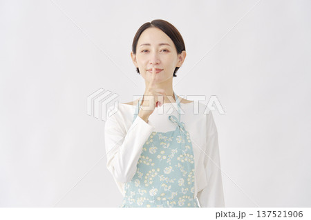 エプロンを着た女性　内緒のジェスチャー　白背景 137521906