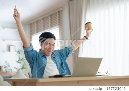 Excited happy boy winner looking at notebook celebrating success 137523043
