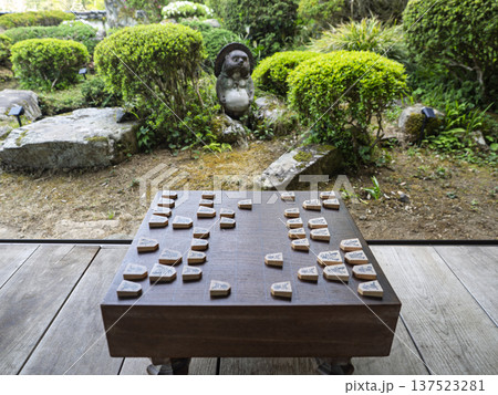 静寂に響く王手。縁側に置かれた将棋盤と庭園を眺める昼下がり 137523281