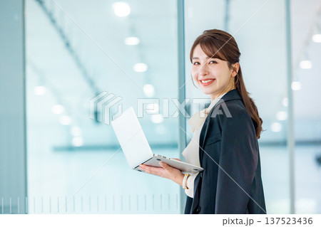 オフィスでノートパソコンを操作する若いビジネスウーマン 137523436