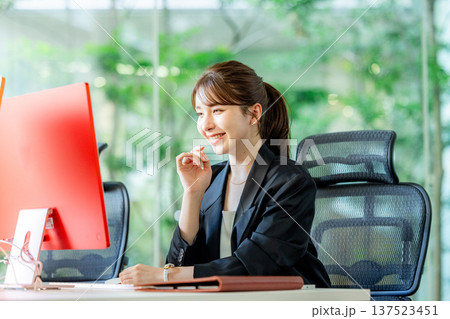 オフィスでパソコンを使って仕事する外国人女性 オフィスでパソコンを使って仕事する外国人女性 137523451