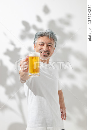 笑顔でビールジョッキを持つ男性 137524284