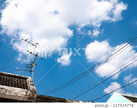 Old TV Antenna on Roof with Blue Sky and White Clouds Background 137524778
