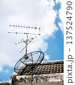 TV Antenna and Satellite Dish on Old Roof Against Blue Sky Background 137524790