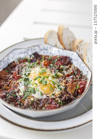 Shakshuka brunch dish on white table at outdoors restaurant in israel Shakshuka brunch dish on white table at outdoors restaurant in israel 137525000