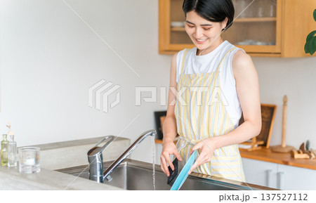 洗い物をするエプロン姿の女性・主婦 洗い物をするエプロン姿の女性・主婦 137527112