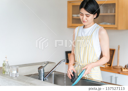 洗い物をするエプロン姿の女性・主婦 137527113