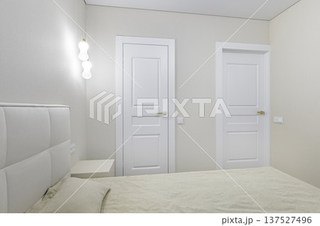 Minimalist Bedroom Interior with White Doors and Modern Pendant Lights Minimalist Bedroom Interior with White Doors and Modern Pendant Lights 137527496