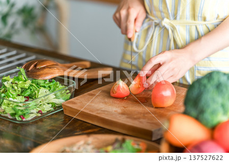 キッチンで料理をする若いアジア人女性（切る・包丁・クッキング・手料理） 137527622