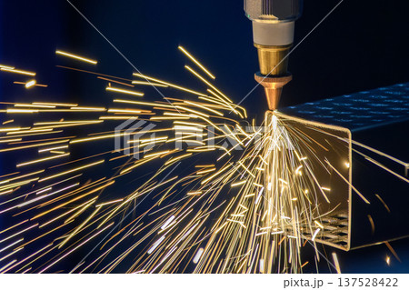 Close-up of a high-precision fiber laser cutting machine processing a square metal tube with intense spark fire. 137528422