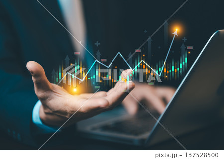 Businessman with rising financial stock market graph on laptop. Concept of investment growth, data analytics, economic success, and digital trading. Businessman with rising financial stock market graph on laptop. Concept of investment growth, data analytics, economic success, and digital trading. 137528500
