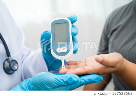 Doctor check diabetes from finger blood sugar level with finger lancet. Doctor check diabetes from finger blood sugar level with finger lancet. 137528562