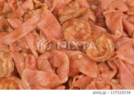 Close up of bicolor pasta with shrimps and tomato sauce Close up of bicolor pasta with shrimps and tomato sauce 137529156