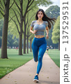 緑地公園をジョギングするスポーツウエアを着た女性 137529531