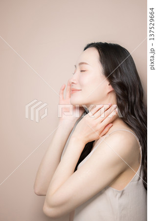 黒髪が綺麗でベージュ背景の若い女性の艶や透明感のあるビューティーイメージ　横顔 137529664