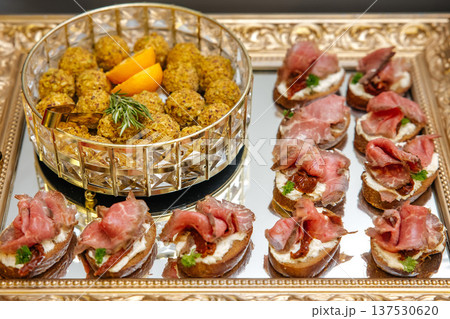 Appetizer platter presenting beef bruschetta and gourmet snack balls Appetizer platter presenting beef bruschetta and gourmet snack balls 137530620
