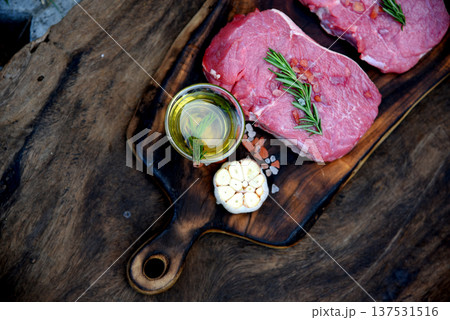 Top view raw beef tender meat steak grill pork barbeque on wooden board. Steak western cuisine ingredient fresh herb meat pepper olive oil garlic chilli tomato salt rosemary on wood plate outdoor. 137531516