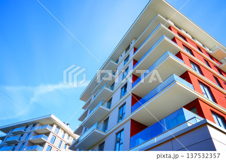 Modern condominium facade background. Facade apartment building under blue sky. Modern facade Modern condominium facade background. Facade apartment building under blue sky. Modern facade 137532357